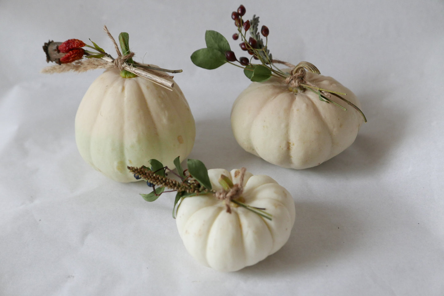 3 white ornamental pumpkins with dried flowers