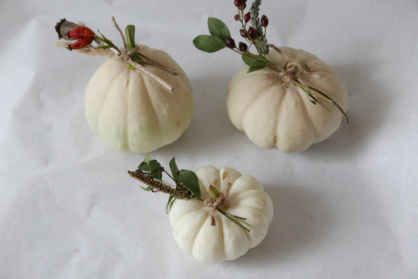 3 white ornamental pumpkins with dried flowers